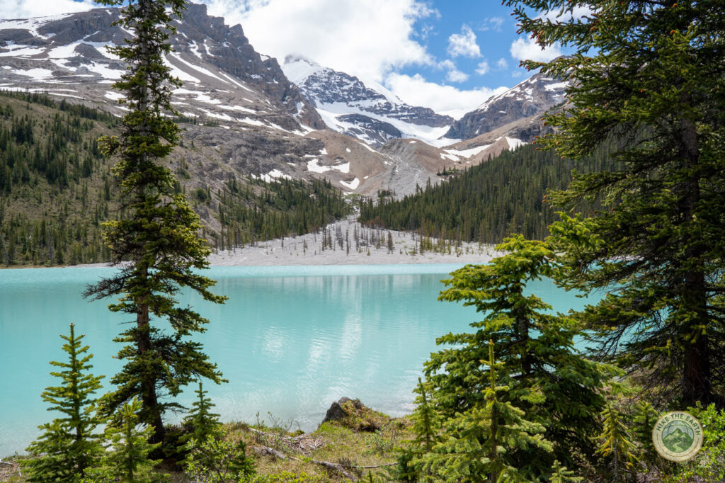 Boundary Lake glacier water seen through the trees on the trail